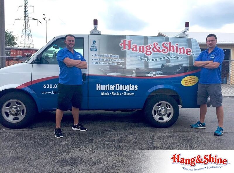 The two owners of Hang and Shine standing beside their van